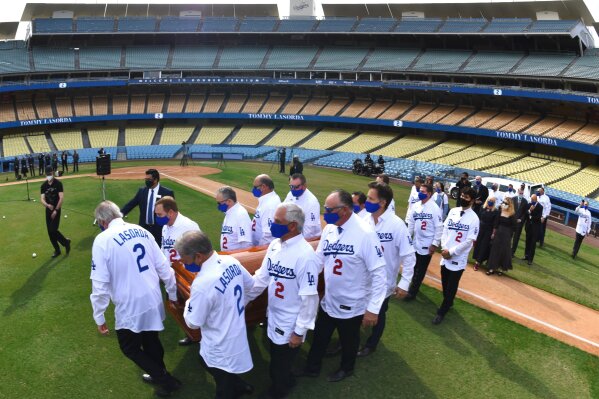 In this photo provided by the Los Angeles Dodgers, the casket of Hall of Fame manager Tommy Lasorda is carried during a ceremony at Dodger Stadium, Tuesday, Jan. 19, 2021, in Los Angeles. (Jon SooHoo/Los Angeles Dodgers via AP)