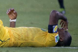 El astro camerunés Samuel Eto'o se lamenta luego de recibir un golpe en el partido del Mundial ante México, el viernes 13 de junio de 2014, en Natal, Brasil (AP Foto/Sergei Grits)
