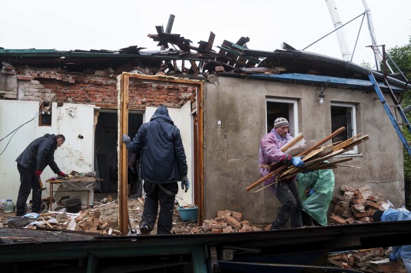 People clear the rubble of a house destroyed by a Russian strike in Korostyshiv, Zhytomyr region, Ukraine, Sunday, May 25, 2025. (AP Photo/Evgeniy Maloletka)