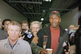 Chicago Bulls Michael Jordan, right, answers reporters questions as he leaves practice at the United Center, Thursday, March 23, 1995, Chicago, Ill. Jordan will play his first game in the New Arena and his first game in Chicago since rejoining the team, when the Bulls play the Orlando Magic on Friday, March 24. (AP Photo/Tim Boyle)