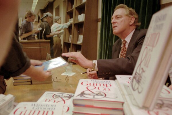 FILE - In this Aug. 21, 1995, file photo, Winston Groom, author of "Forrest Gump," the book on which the film was based, signs copies of "Gump & Co.," the sequel to "Forrest Gump", at a New York City bookstore. Groom, the author of the novel "Forrest Gump" that was made into a six-Oscar winning 1994 movie that became a soaring pop culture hit, has died, an Alabama official close to the writer said Thursday, Sept. 17, 2020. He was 77. (AP Photo/Anders Krusberg, File)