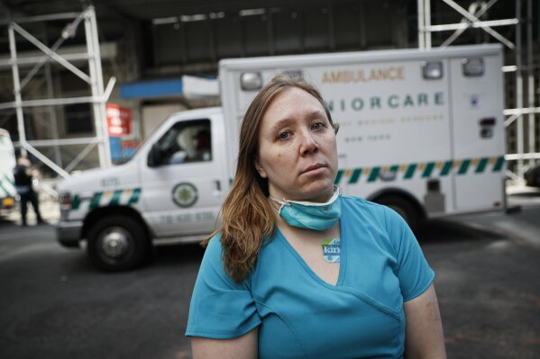 Registered Nurse Elizabeth Schafer, 36, of South St. Paul, Minn., stands for a portrait before entering Beth Israel Mount Sinai Hospital for her second day volunteering to combat the COVID-19 pandemic, Wednesday, April 1, 2020, in New York. Schafer left her home in the Midwest to volunteer in New York where she says the situation inside the hospital is grim. "I took an oath as a nurse to do no harm and just go where I was needed," Schafer said. "I told my students, you step up to the plate when you're needed as a nurse, all the time, no matter what. And so right now, you either go to the West Coast or the East Coast as a nurse. And so here I am." (AP Photo/John Minchillo)