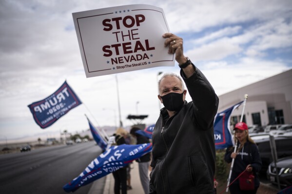 FILE - Supporters of President Donald Trump hold signs as they stand outside of the Clark County Elections Department in North Las Vegas,Nov. 7, 2020. As former President Donald Trump makes a comeback bid to return to power, Republicans in Congress have become even more likely to cast doubts on President Joe Biden's 2020 victory.(AP Photo/Wong Maye-E, File)
