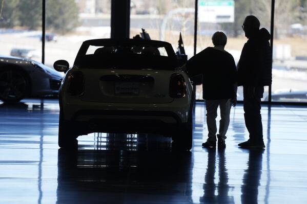 File - Car shoppers consider a 2022 Cooper convertible on display in a Mini dealership in Highlands Ranch, Colo., on Friday, Feb. 18, 2022. A low credit score can hurt your ability to take out a loan, secure a good interest rate, or increase a credit card spending limit. (AP Photo/David Zalubowski, File)