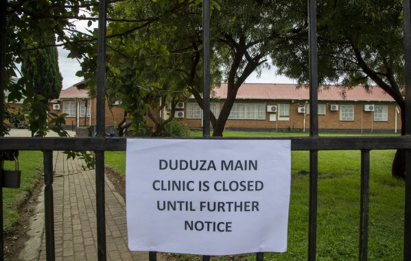 A note displayed at the entrance of indefinitely closed clinic after a nurse tested positive for Covid-19, in Duduza, east of Johannesburg, South Africa, Thursday, April 2, 2020. South Africa went into a nationwide lockdown for 21 days in an effort to mitigate the spread to the coronavirus. The new coronavirus causes mild or moderate symptoms for most people, but for some, especially older adults and people with existing health problems, it can cause more severe illness or death. (AP Photo/Themba Hadebe)