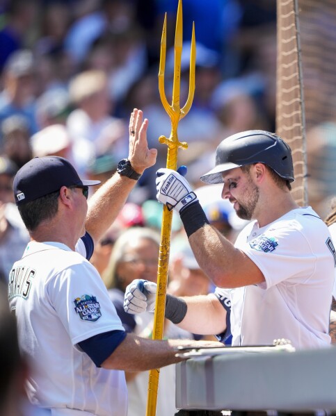 Seattle Mariners' Julio Rodriguez holds a trident in the dugout after  hitting a home run against the Oakland Athletics in a baseball game Monday,  Aug. 28, 2023, in Seattle. (AP Photo/Lindsey Wasson