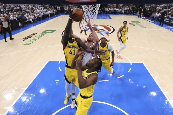 Oklahoma City Thunder forward Chet Holmgren (7), Indiana Pacers forward Pascal Siakam (43) and forward Aaron Nesmith (23) reach for the ball during Game 1 of the NBA Finals basketball series Thursday, June 5, 2025, in Oklahoma City. (Matthew Stockman/Pool Photo via AP)