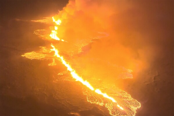 This image made from video provided by the Icelandic Coast Guard shows magma flow on a hill near Grindavik on Iceland's Reykjanes Peninsula sometime around late Monday, Dec. 18, or early Tuesday, Dec. 19, 2023. A volcanic eruption started Monday night on Iceland's Reykjanes Peninsula, turning the sky orange and prompting the country’s civil defense to be on high alert. (Icelandic coast guard via AP)