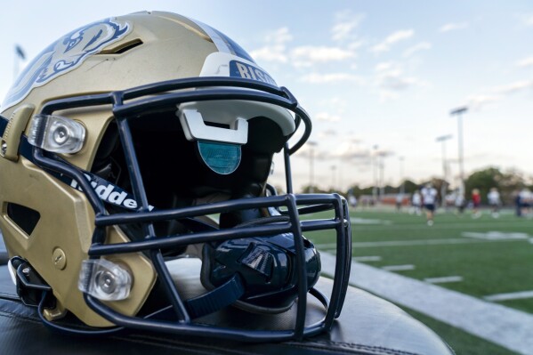 A football helmet developed by Gallaudet University with AT&T for Deaf and hard-of-hearing players is seen during Gallaudet football practice at Hotchkiss Field in Washington, Tuesday, Oct. 10, 2023. The innovation is the latest example of the private university for the Deaf and hard of hearing in Washington being an incubator for technology that makes sports and life more inclusive. The way the helmet works by replacing audio with visual cues could also have far-reaching applications into the real world. (AP Photo/Stephanie Scarbrough)