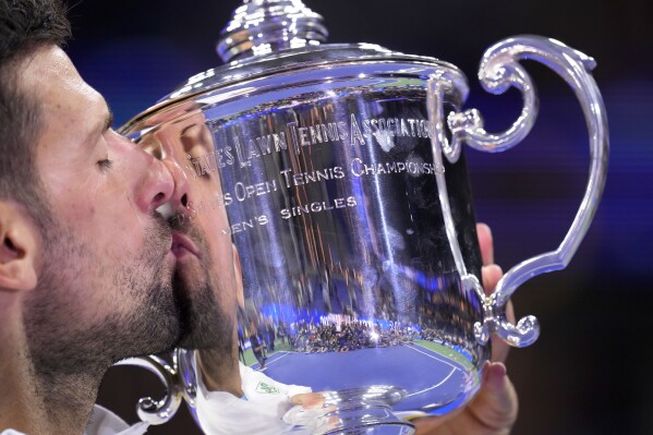 Novak Djokovic, of Serbia, kisses the championship trophy after defeating Daniil Medvedev, of Russia, in the men's singles final of the U.S. Open tennis championships, Sunday, Sept. 10, 2023, in New York. (AP Photo/Manu Fernandez)