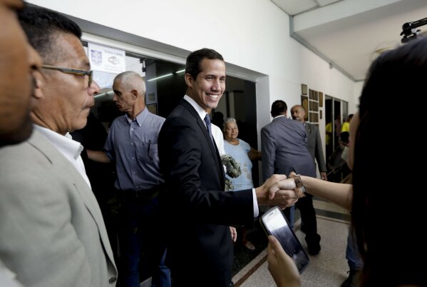 
              Venezuela's self-proclaimed interim president Juan Guaido shakes the hand of a supporter as he arrives for a meeting with electricity experts in Caracas, Venezuela, Thursday, March 28, 2019. The Venezuelan government on Thursday said it has barred Guaido from holding public office for 15 years, though the National Assembly leader responded soon afterward that he would continue his campaign to oust President Nicolas Maduro.  (AP Photo/Natacha Pisarenko)
            