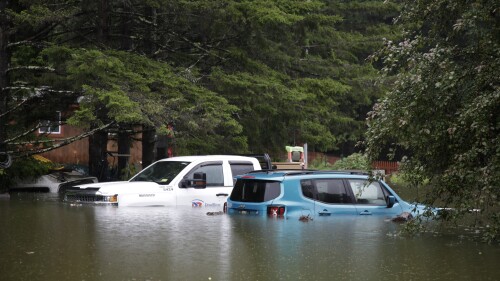 Floodwaters rise in Bridgewater, Vt., Monday, July 10, 2023, submerging parked vehicles and threatening homes near the Ottauquechee River. Heavy rain drenched part of the Northeast, washing out roads, forcing evacuations and halting some airline travel. (AP Photo/Hasan Jamali)