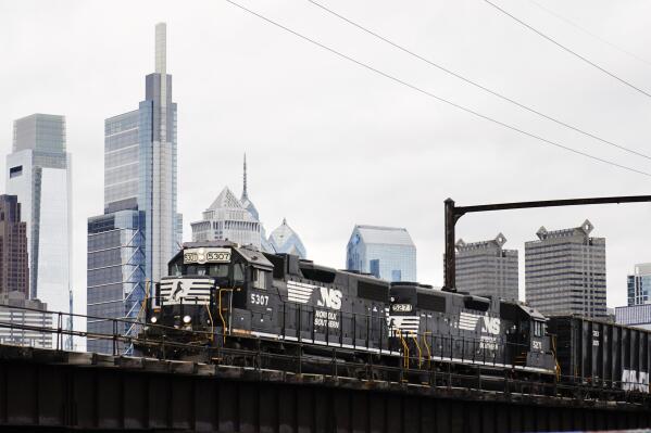FILE - A Norfolk Southern freight train moves along elevated tracks in Philadelphia, Wednesday, Oct. 27, 2021. Railroads will be required to maintain two-person crews under a new rule announced Wednesday, July 27, 2022,  that will thwart the industry’s efforts to cut crews down to one person.   (AP Photo/Matt Rourke)