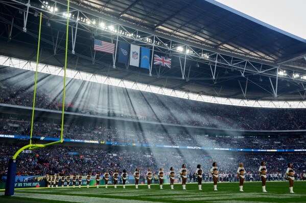 Sun filters through the stadium as cheerleaders line up before an NFL football game between Tennessee Titans and Los Angeles Chargers at Wembley stadium in London, Sunday, Oct. 21, 2018. (AP Photo/Matt Dunham, File)