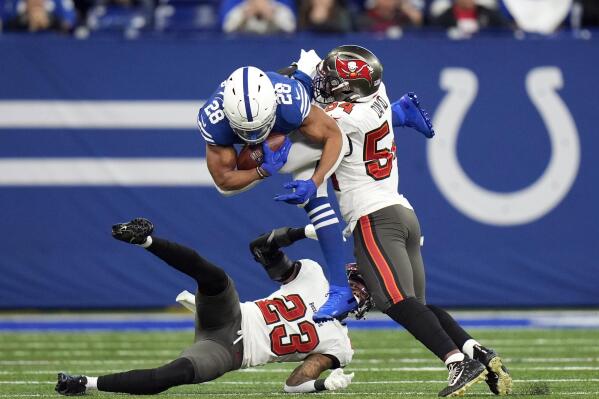 Indianapolis Colts' Jonathan Taylor (28) is tackled by Tampa Bay Buccaneers' Sean Murphy-Bunting (23) and Lavonte David (54) during the first half of an NFL football game, Sunday, Nov. 28, 2021, in Indianapolis. (AP Photo/AJ Mast)