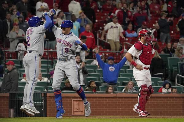 New York Mets' Brandon Nimmo (9) is congratulated by teammate Dominic Smith (2) after hitting a two-run home run as St. Louis Cardinals catcher Andrew Knizner, right, stands at the plate during the ninth inning of a baseball game Monday, April 25, 2022, in St. Louis. (AP Photo/Jeff Roberson)