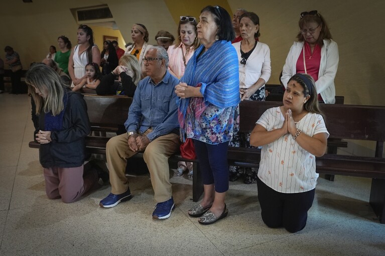 People pray during an Ash Wednesday Mass at the Our Lady of Charity shrine, known as La Ermita, in Miami, Florida, Wednesday, Feb. 14, 2024. The Vatican-recognized Virgin, venerated by Catholics and followers of Afro-Cuban Santeria traditions, is at the heart of Cuban identity, uniting compatriots from the Communist-run Caribbean island to those who were exiled or emigrated to the U.S. (AP Photo/Marta Lavandier)