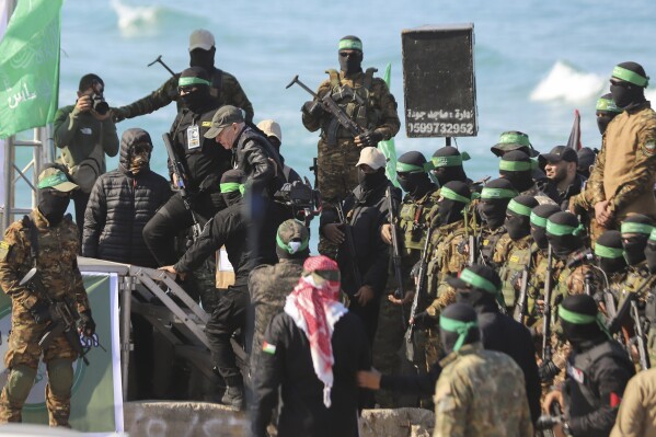 American-Israeli hostage Keith Siegel, 65, center left, is escorted by Hamas fighters as he is handed over to the Red Cross in Gaza City, Saturday Feb.1, 2025.(AP Photo/Mohammed Hajjar)