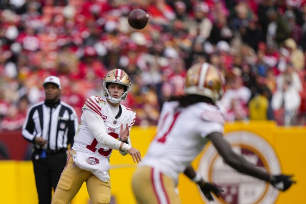 San Francisco 49ers quarterback Brock Purdy (13) throwing a pass to wide receiver Brandon Aiyuk (11) during the second half of an NFL football game, Sunday, Dec. 31, 2023, in Landover, Md. (AP Photo/Mark Schiefelbein)