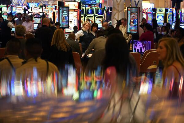 FILE - In this June 24, 2021, file photo, people crowd the casino during the opening night of the Resorts World Las Vegas hotel-casino in Las Vegas. Nevada casinos set another winnings record in July, riding a streak of robust revenues that has the state reaping the tax benefit, state gambling regulators said Thursday, Aug. 26, 2021. (AP Photo/John Locher, File)