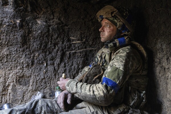 A Ukrainian serviceman from the 3rd Assault Brigade who goes by the call sign 'Sheva' eats a piece of bread in a trench on his position at the frontline a few kilometers from Andriivka, Donetsk region, Ukraine, Saturday, September 16, 2023. The brigade announced Friday they had recaptured the war-ravaged settlement which is less 10 kilometers (6 miles) south of Russian-occupied city of Bakhmut, in the country's embattled east. (AP Photo/Alex Babenko).
