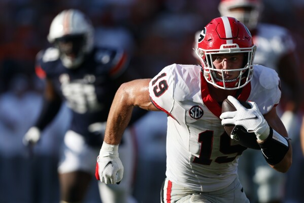 FILE - Georgia tight end Brock Bowers (19) carries the ball after a reception during the second half of an NCAA football game against Auburn, Saturday, Sept. 30, 2023, in Auburn, Ala. Bowers is a possible first round pick in the NFL Draft. (AP Photo/Butch Dill, File)