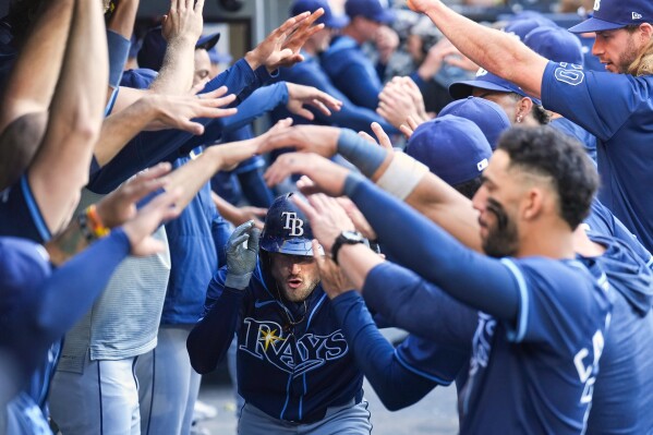 Tampa Bay Rays' Brandon Lowe, center, is greeted in the dugout after hitting a two-run home run in the ninth inning of a baseball game against the Toronto Blue Jays in Toronto, Thursday, May 15, 2025. (Nathan Denette/The Canadian Press via AP)