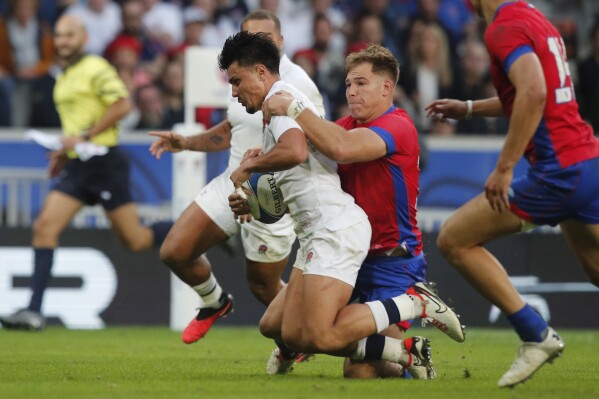England's Marcus Smith is tackled by Chile's Domingo Saavedra before scoring a try during the Rugby World Cup Pool D match between England and Chile at the Stade Pierre Mauroy in Villeneuve-d'Ascq, outside Lille, Saturday, Sept. 23, 2023. (AP Photo/Michel Spingler)