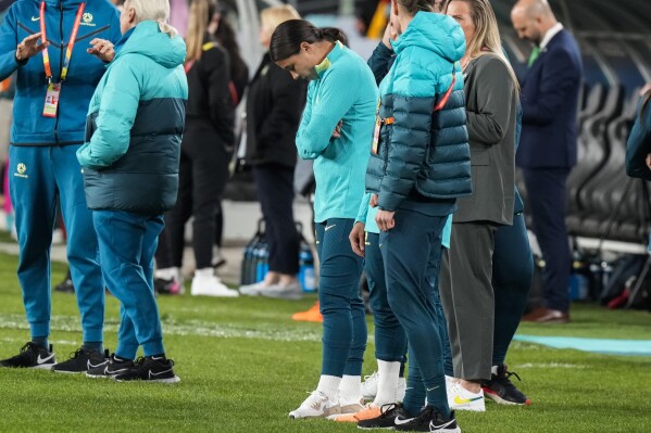 Australia's Sam Kerr, center, stands at the pitch prior the Women's World Cup soccer match between Australia and Ireland at Stadium Australia in Sydney, Australia, Thursday, July 20, 2023. Kerr is injured and won't play her's team first tournament game. (AP Photo/Rick Rycroft)