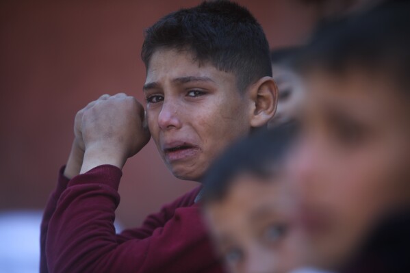 A Palestinian boy cries for his relatives who were killed in the Israeli bombardment of the Gaza Strip, at Nasser hospital in Khan Younis, Friday, Dec. 15, 2023. (AP Photo/Mohammed Dahman)