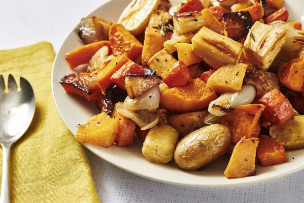 This image provided by Cheyenne Cohen shows roasted fall vegetables on a serving plate. Many a Thanksgiving gathering these days will include meat eaters, vegetarians and vegans around the same table. AP food writer Katie Workman has practice creating one feast that can please all of them without a lot of extra work. (Cheyenne Cohen via AP)