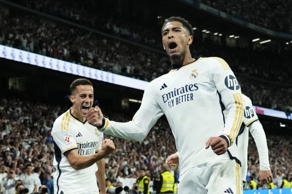 Real Madrid's Jude Bellingham, centre, celebrates with teammates after scoring his side's third goal during the Spanish La Liga soccer match between Real Madrid and Barcelona at the Santiago Bernabeu stadium in Madrid, Spain, Sunday, April 21, 2024. (AP Photo/Jose Breton)