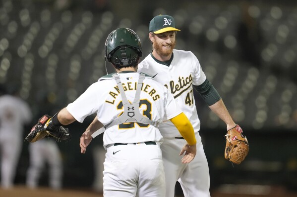 Oakland Athletics catcher Shea Langeliers, left, celebrates with pitcher Michael Kelly after the Athletics defeated the Pittsburgh Pirates in a baseball game in Oakland, Calif., Monday, April 29, 2024. (AP Photo/Jeff Chiu)