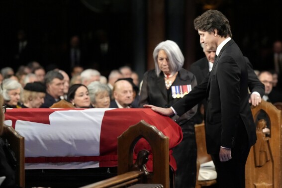 Prime Minister Justin Trudeau places his hand on the casket during the funeral of former prime minister Brian Mulroney, in Montreal, Saturday, March 23, 2024. (Ryan Remiorz /The Canadian Press via AP)