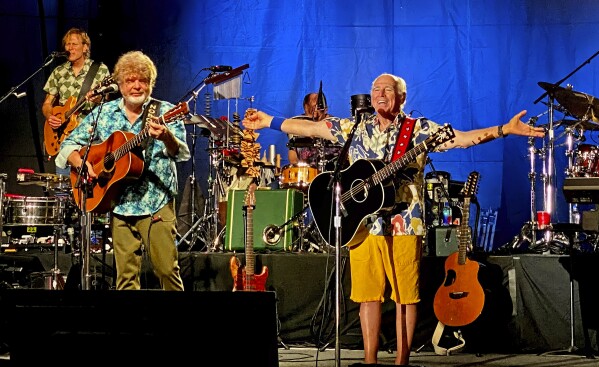 FILE - In this Thursday, Feb. 9, 2023, photo provided by the Florida Keys News Bureau, singer-songwriter Jimmy Buffett, right, along with members of his Coral Reefer Band including Mac McAnally, center, perform during a concert in Key West, Fla. (Howard Livingston/Florida Keys News Bureau via AP)