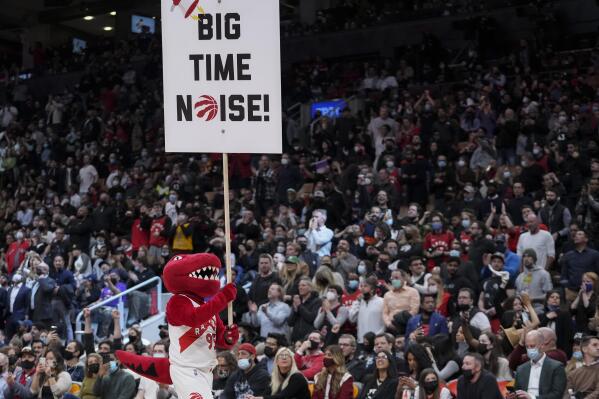 The Toronto Raptors team mascot pumps up the crowd as the Raptors play against the Brooklyn Nets during the second half of an NBA basketball game in Toronto on Tuesday, March 1, 2022. The Raptors were permitted a full crowd of 19,800 at Scotiabank Arena for the first time since Dec. 13, after the Ontario government accelerated the lifting of restrictions. (Nathan Denette/The Canadian Press via AP)