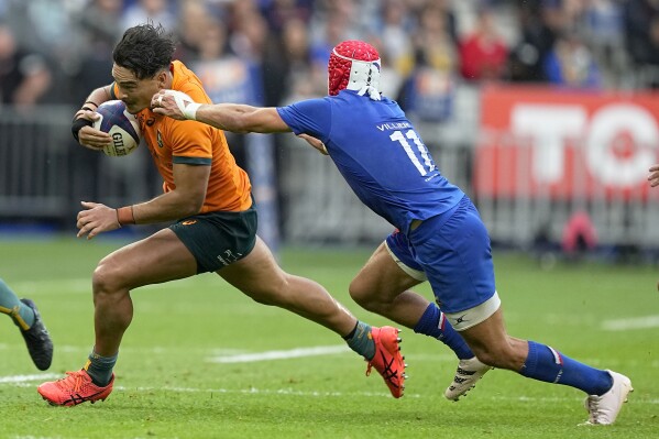 Australia's Jordan Petaia , left, and France's Gabin Villiere challenge for the ball during the International Rugby Union World Cup warm-up match between France and Australia at the Stade de France stadium in Saint Denis, outside Paris, Sunday, Aug. 27, 2023. (AP Photo/Michel Euler)