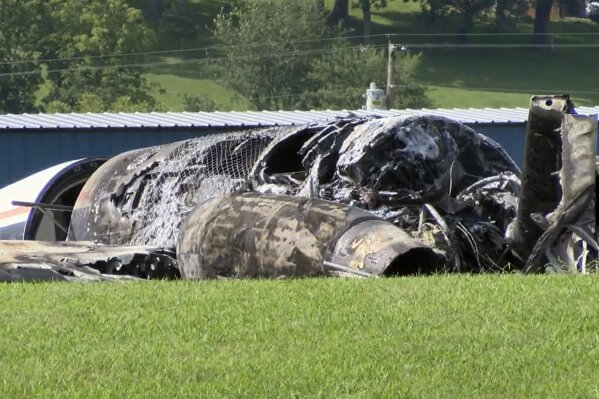 The burned remains of a plane that was carrying NASCAR television analyst and former driver Dale Earnhardt Jr. lies near a runway Thursday, Aug. 15, 2019, in Elizabethton, Tenn. Officials said the Cessna Citation rolled off the end of a runway and caught fire after landing at Elizabethton Municipal Airport. Earnhardt's sister, Kelley Earnhardt Miller, tweeted that "everyone is safe and has been taken to the hospital for further evaluation." (WJHL TV via AP)