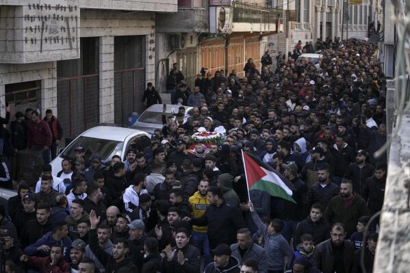 Mourners carry the body of Palestinian Samir Aslan, 41, during his funeral in the West Bank refugee camp of Qalandia, north of Ramallah, Thursday, Jan. 12, 2023. The Israeli army killed Samir Aslan during an arrest raid in the Qalandia refugee camp. The army says they shot at Palestinians who were throwing stones. Aslan's family says the military killed him as he was watching his son's arrest from his rooftop. (AP Photo/Mahmoud Illean)