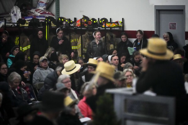 People gather during an auction of books at 56th annual mud sale to benefit the local fire department in Gordonville, Pa., Saturday, March 9, 2024. Mud sales are a relatively new tradition in the heart of Pennsylvania's Amish country, going back about 60 years and held in early spring as the ground begins to thaw but it's too early for much farm work. (AP Photo/Matt Rourke)