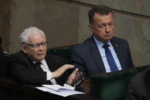 The leader of Poland's ruling party Jaroslaw Kaczynski, left, and defense minister, Mariusz Blaszczak ,right, during parliament vote to confirm that a government-planned controversial referendum on migration will be held alongside key parliamentary elections on Oct. 15, at the lower house of parliament in Warsaw, Poland, on Thursday, Aug. 17, 2023. Critics say the referendum is a campaign ploy by ruling Law and Justice party to discredit the opposition and rally voters around government politics. (AP Photo/Czarek Sokolowski)