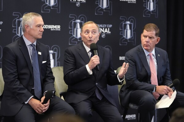 NHL Commissioner Gary Bettman, center, speaks during a news conference before Game 1 of the NHL hockey Stanley Cup Finals, Saturday, June 8, 2024, in Sunrise, Fla. At left is Shane Jacobson, CEO of the V Foundation for Cancer Research, and at right is NHL Players Association Director Marty Walsh. (AP Photo/Lynne Sladky)