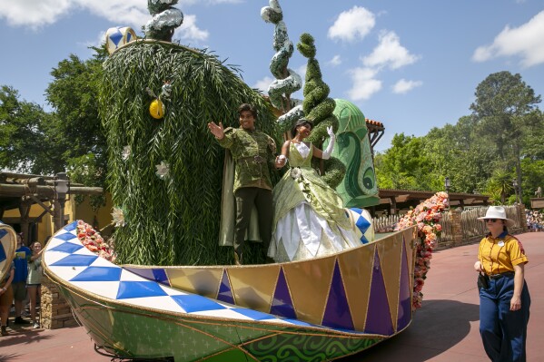 Actors dressed as Princess Tiana and Prince Naveen from The Princess and the Frog perform on a float during the Festival of Fantasy Parade at Magic Kingdom Park at Walt Disney World Resort in Lake Buena Vista, Florida, on April 18, 2022. A new attraction starring the first African American princess in Disney's kingdom is opening at the company's theme parks in Florida and California. Some Disney followers see it as fitting that the attraction starring Tiana from the 2009 film “The Princess and the Frog” is opening in space formerly occupied by the Splash Mountain ride. (AP Photo/Ted Shaffrey, file)