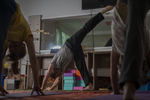 Serhii Zaloznyi, center, a 52-year-old yoga instructor, holds a yoga session in a basement in Kramatorsk, Donetsk region, Ukraine, Thursday, Sept. 14, 2023. In a basement in one of the front-line cities in the Donetsk region, people gather three times a week in the morning for yoga to alleviate the stress caused by Russia’s constant shelling. (AP Photo/Hanna Arhirova)