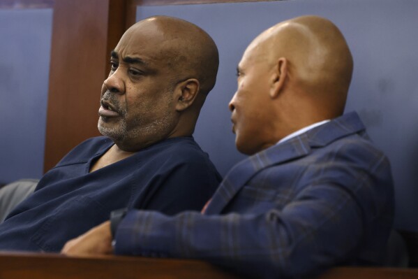 Duane "Keffe D" Davis, left, listens to his attorney Carl Arnold during his status hearing at the Regional Justice Center, on Tuesday, Feb. 20, 2024, in Las Vegas. A trial date has been pushed back from June to November for the former Los Angeles-area gang leader charged with killing hip-hop music icon Tupac Shakur in 1996 in Las Vegas. Davis' new attorney said Tuesday in court that he expects to be able to post bail soon to be released from jail to house arrest. (Bizuayehu Tesfaye/Las Vegas Review-Journal via AP, Pool)