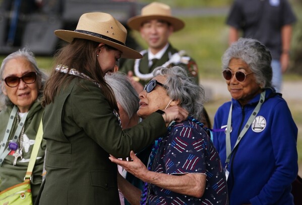CORRECTS LAST NAME OF KELSEA TO LARSEN FROM HOLBROOK - Minidoka survivor Fujiko Tamura Gardner, center, is honored with a lei from her granddaughter, ranger Kelsea Larsen, during a closing ceremony at Minidoka National Historic Site, Sunday, July 9, 2023, in Jerome, Idaho. (AP Photo/Lindsey Wasson)
