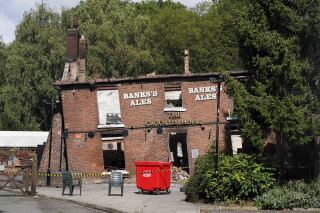 FILE - The burnt remains of The Crooked House pub in Himley. England, Aug. 7, 2023. British police said Thursday Aug. 24, 2023, two men have been arrested on suspicion of burning down an historic English pub that was famous for its lopsided walls and sagging foundation. (Jacob King/PA via AP)