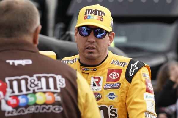 Kyle Busch talks to a crew members before practice for the NASCAR Cup Series auto race at Martinsville Speedway, Saturday, Oct. 29, 2022, in Martinsville, Va. (AP Photo/Chuck Burton)