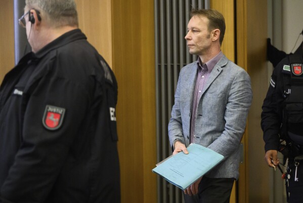 Christian B. centre, arrives at the start of his trial, at Braunschweig district court, in Brunswick, Germany, Friday, Feb. 16, 2024. A man who is also a suspect in the disappearance of British toddler Madeleine McCann goes on trial Friday over several sexual offenses he is alleged to have committed in Portugal between 2000 and 2017. (Julian Stratenschulte/dpa via AP)