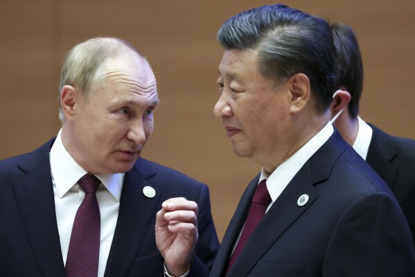 FILE- Russian President Vladimir Putin, left, gestures while speaking to Chinese President Xi Jinping during the Shanghai Cooperation Organization (SCO) summit in Samarkand, Uzbekistan, Sept. 16, 2022. Putin will this week participate in his first multilateral summit since an armed rebellion rattled Russia. Analysts say his participation at a virtual summit of the Shanghai Cooperation Organization on Tuesday is an opportunity to show he is in control after a short-lived insurrection by Wagner mercenary chief Yevgeny Prigozhin. . (Sergei Bobylev, Sputnik, Kremlin Pool Photo via AP, File)